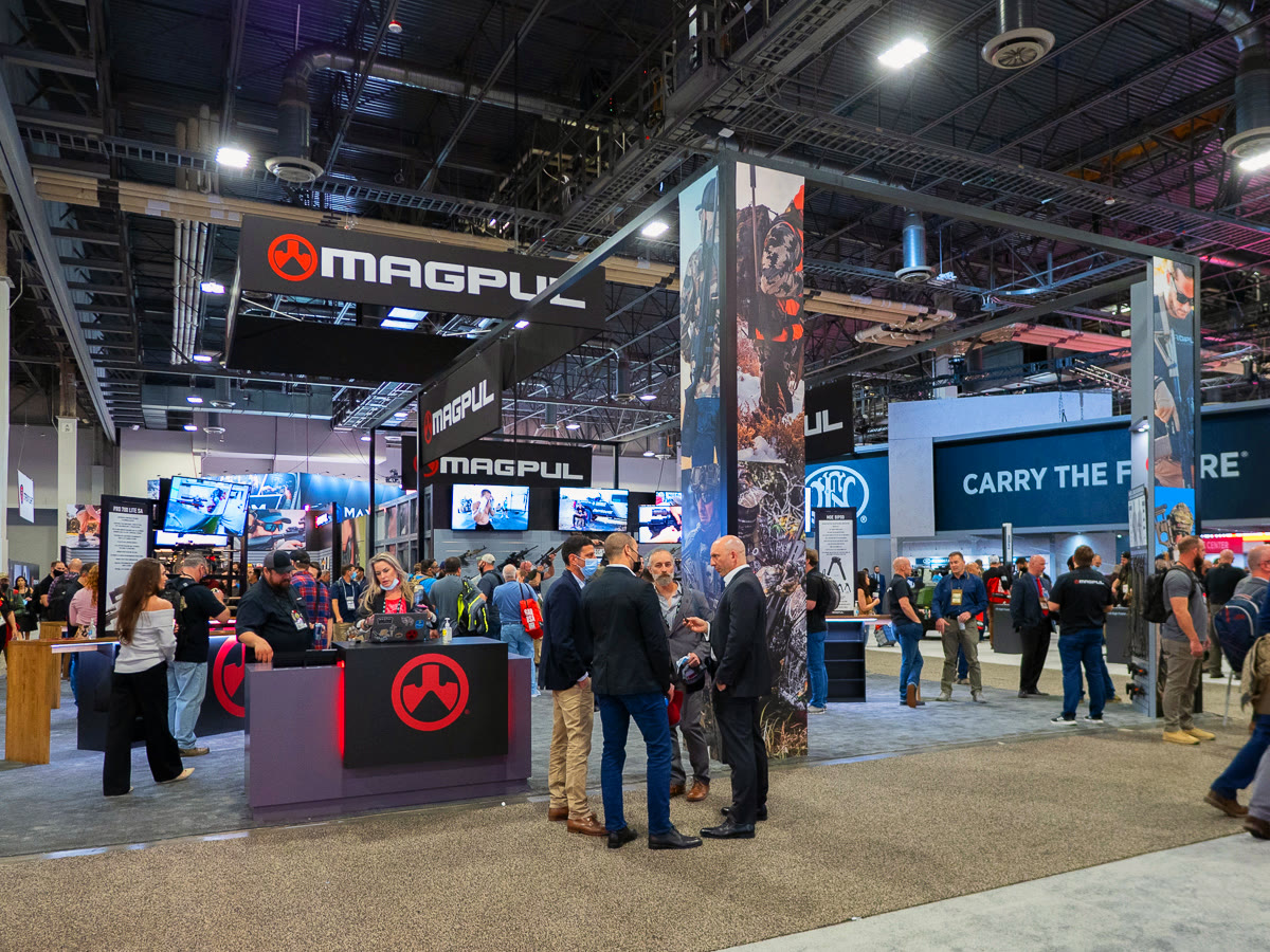 Magpul trade-show stand with screens, product walls and visitors