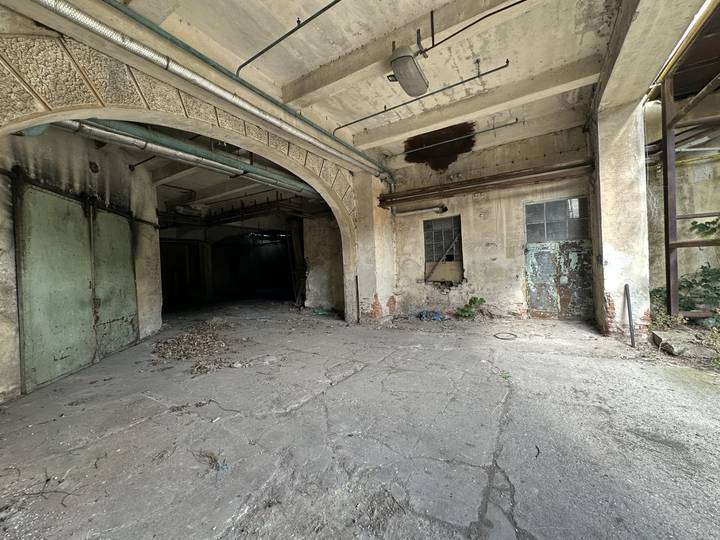 Arched vehicle bay opening off a concrete apron