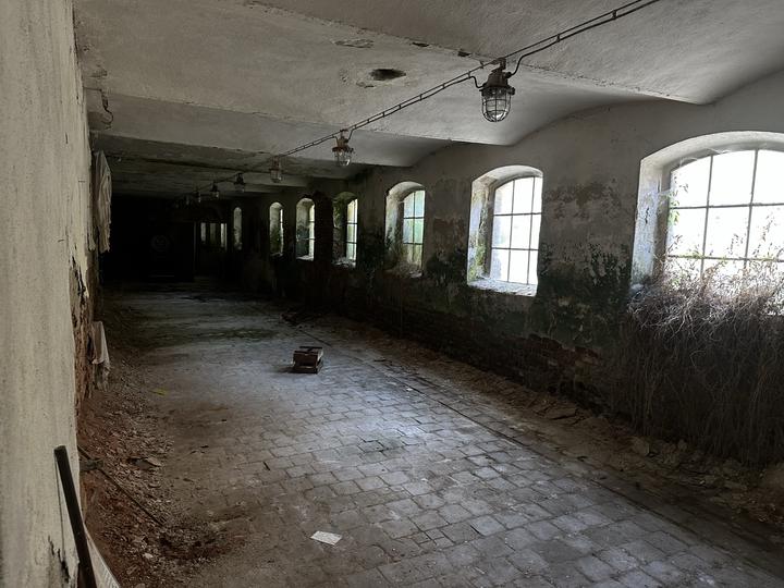 Vaulted hall with arched windows and a brick-paved floor