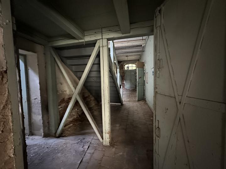 Passage with timber cross-bracing and a braced door standing open