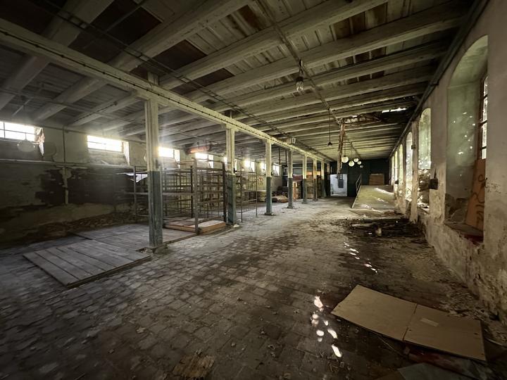 Columned hall with racking along one side and a beamed ceiling