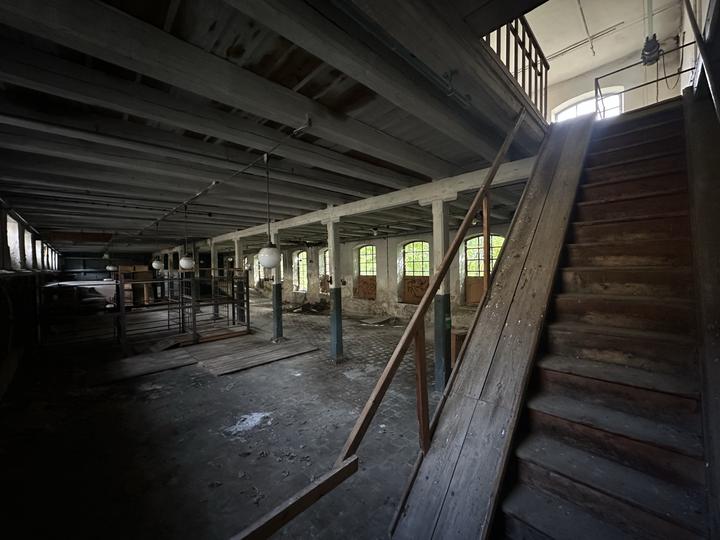 Open timber stair rising from a columned hall