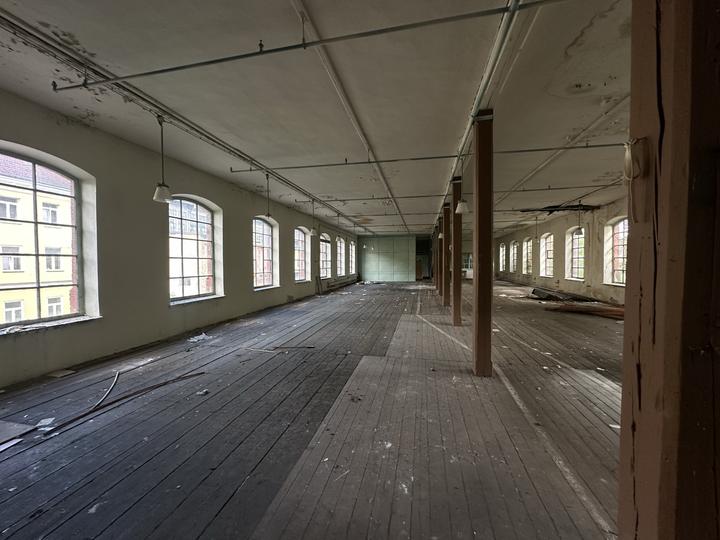 Upper storey with a plank floor and a run of arched windows