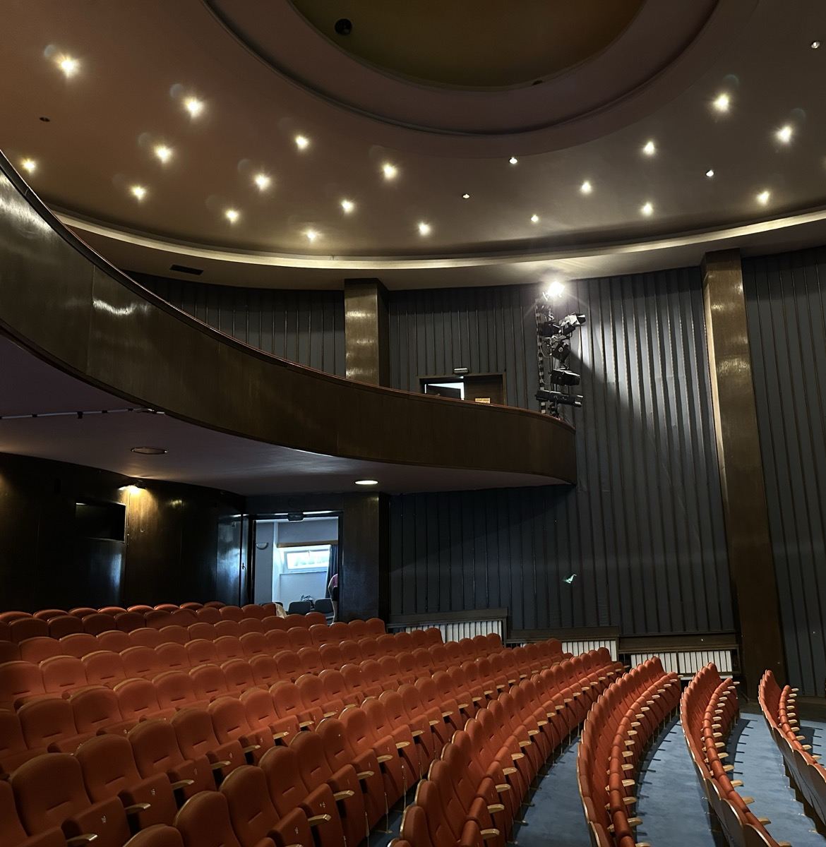 Auditorium with balcony seating and a lit ceiling
