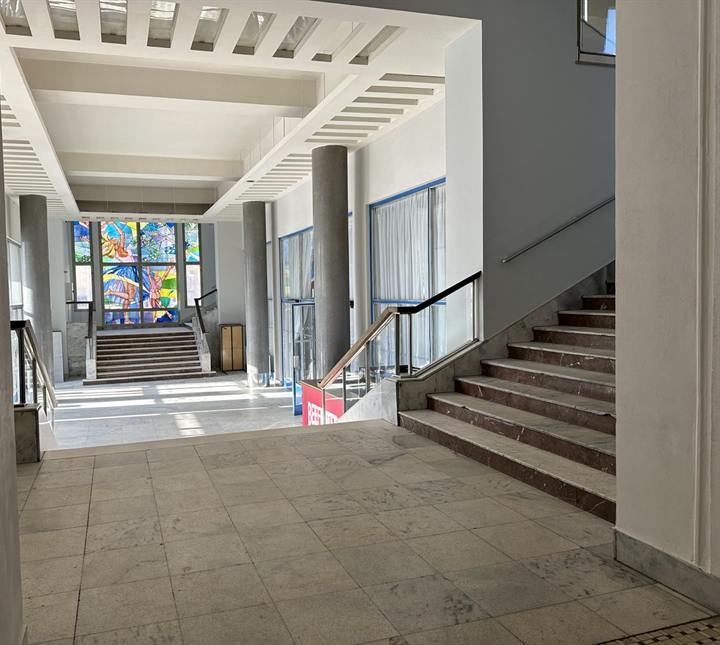 Entrance hall with columns, stained glass and a stone staircase