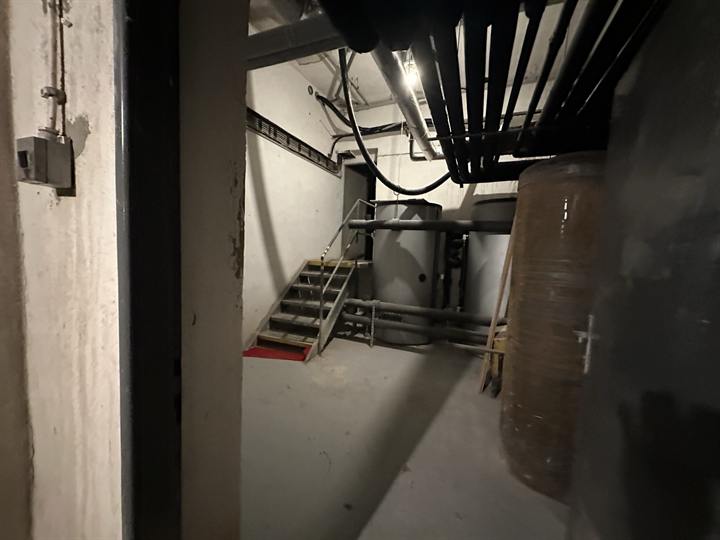 Plant room with tanks, pipework and a steel access stair
