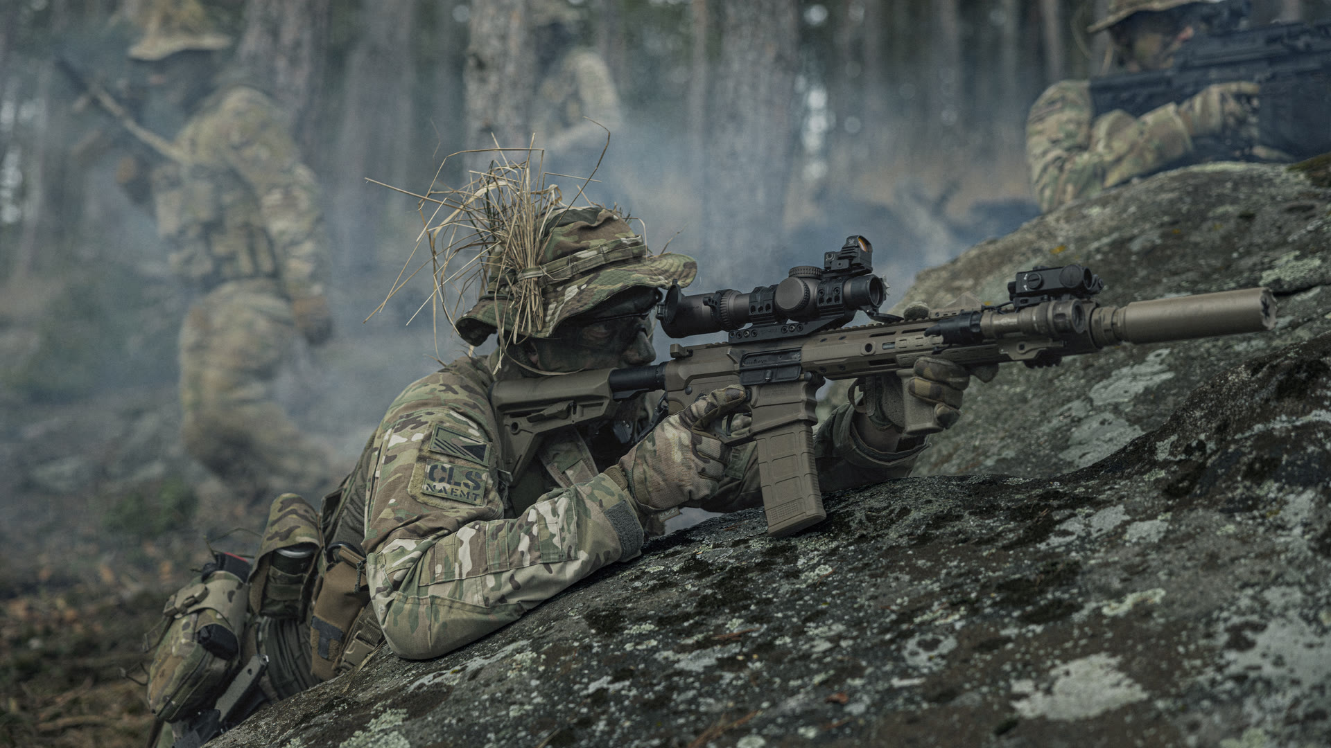 Mission High Ground — Schütze mit schallgedämpftem Karabiner auf einem Felsen, das Team bewegt sich durch einen nebligen Wald