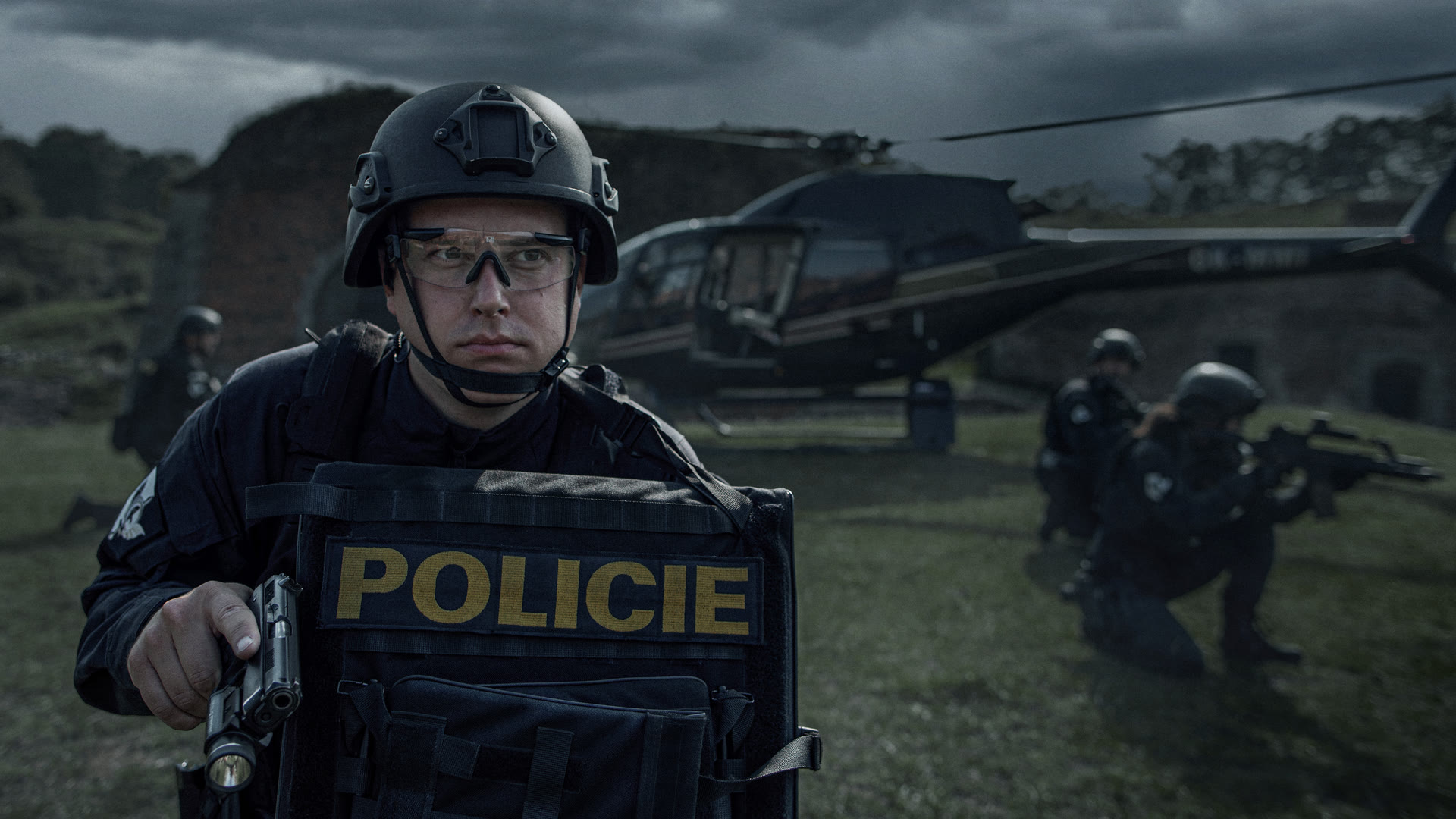 Mission Iron Wall — Polizeioperator mit ballistischem Schild, dahinter Team und Hubschrauber