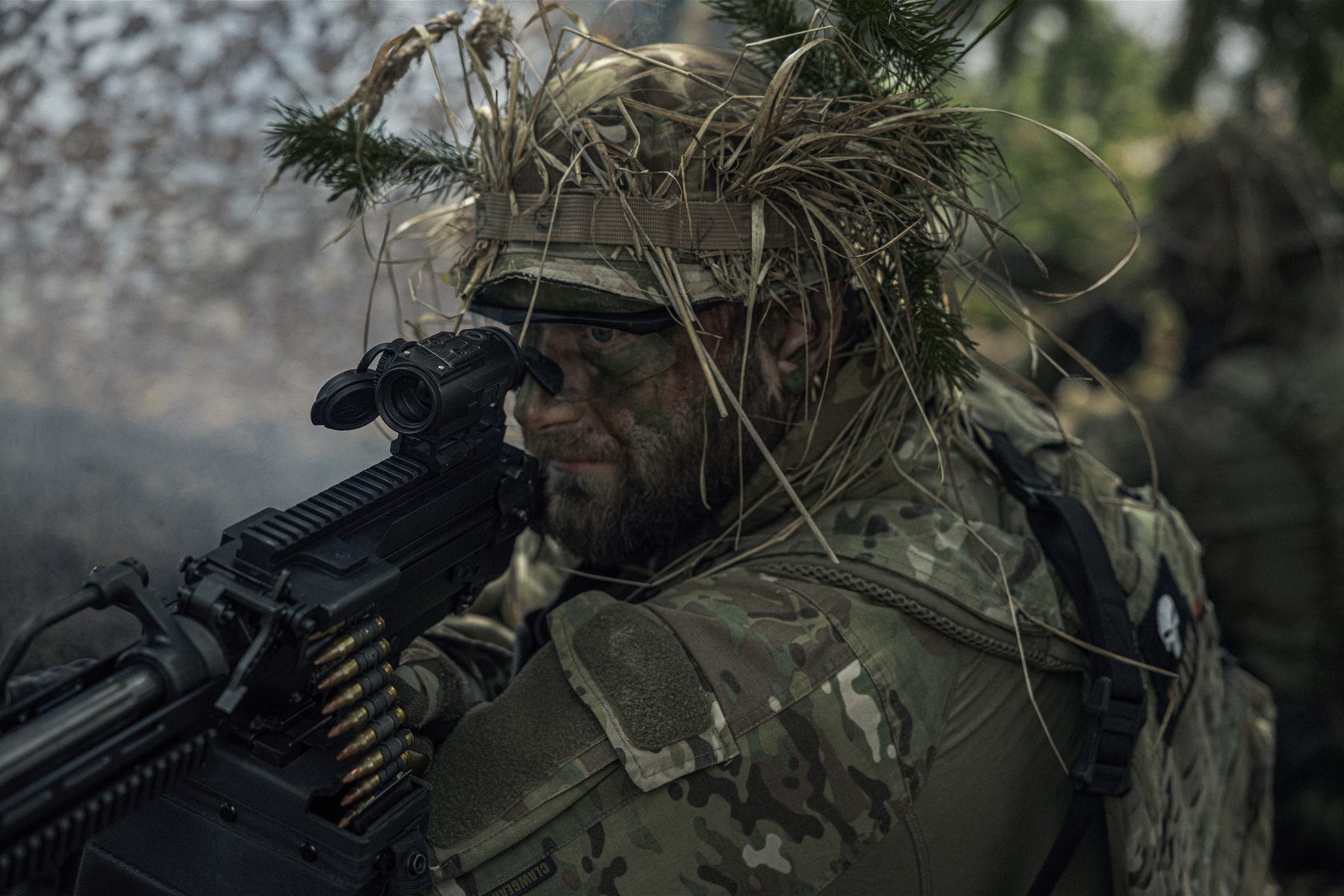 Machine gunner in field camouflage behind the sights