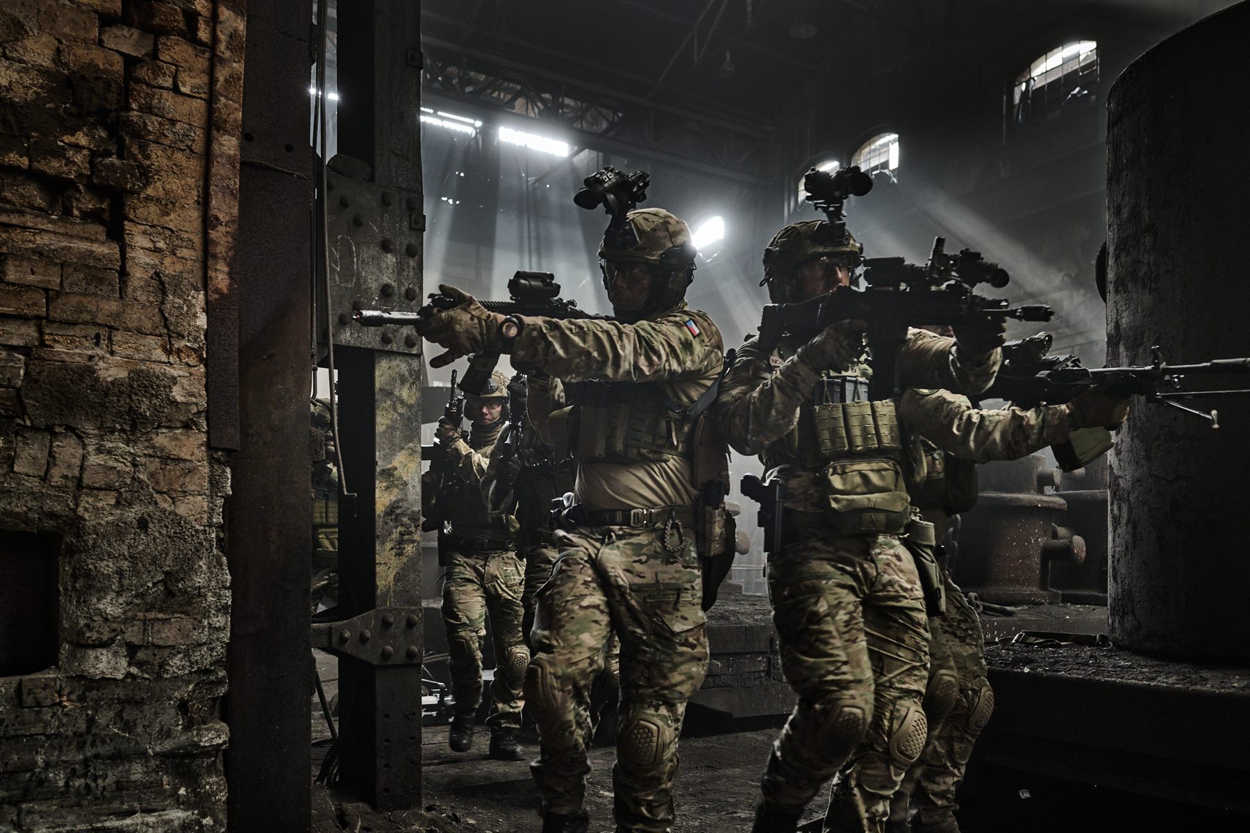 Two soldiers moving through an industrial hall