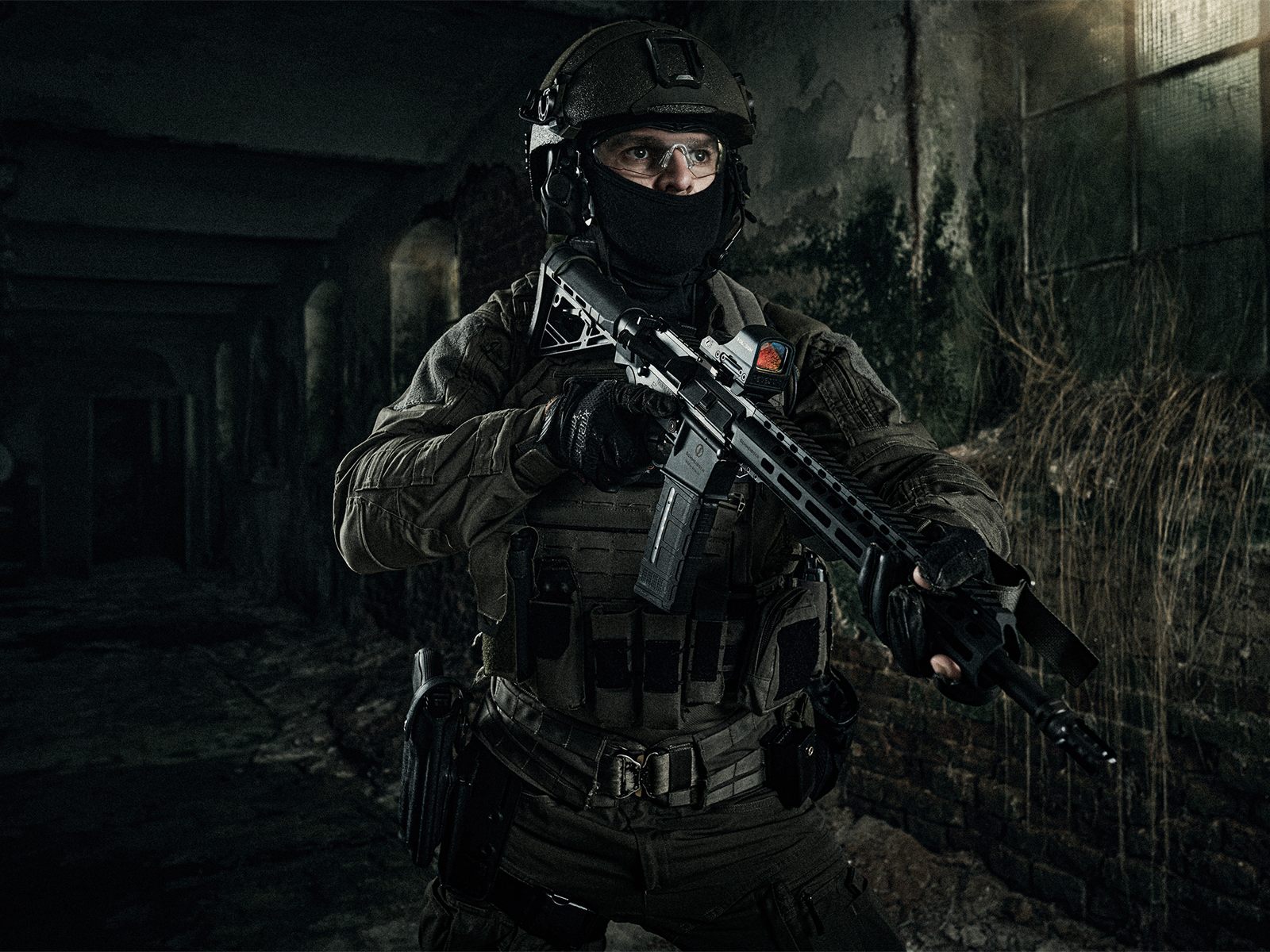 Operator mit Schmeisser-Gewehr auf AR15-Plattform und HOLOSUN-Visier in einer verfallenen Industriehalle