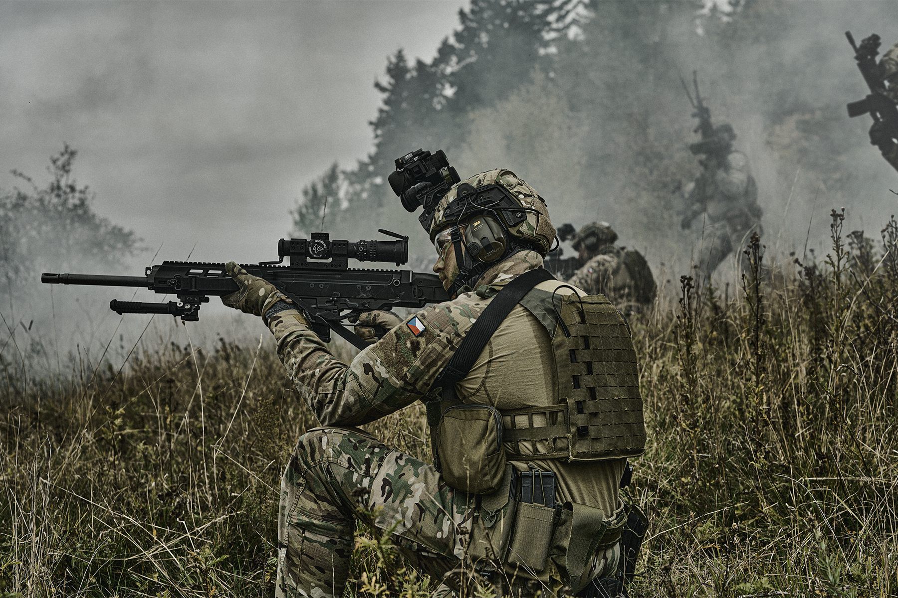 Operator aiming a rifle with an optic in the field